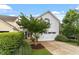The two-car garage features a white garage door that complements the light gray exterior at 208 Jones Hill Rd, Holly Springs, NC 27540
