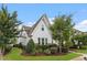 Beautifully landscaped house with white siding, red brick facade, and lush green lawn at 208 Jones Hill Rd, Holly Springs, NC 27540