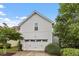 The two-car garage features a white garage door that complements the light gray exterior at 208 Jones Hill Rd, Holly Springs, NC 27540
