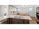 Open concept kitchen and living area with granite counters, stainless steel faucet and a view of the outdoor patio at 208 Jones Hill Rd, Holly Springs, NC 27540