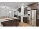 Open-concept kitchen featuring stainless steel appliances, a fireplace, granite countertops, and dark brown cabinetry at 208 Jones Hill Rd, Holly Springs, NC 27540