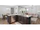 Modern kitchen features a granite countertop island with a stainless steel dishwasher and an open living area at 208 Jones Hill Rd, Holly Springs, NC 27540