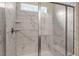 A large glass-enclosed shower features white marble tiles and a built-in bench at 208 Jones Hill Rd, Holly Springs, NC 27540