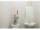 Elegant half bathroom featuring a pedestal sink, toilet, and modern mirror for a stylish, convenient space at 215 Carova Bnd, Apex, NC 27539