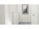 Neutral hallway with gray carpeting and framed artwork at 215 Carova Bnd, Apex, NC 27539