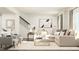 Bright living room with stylish sofa, accent chairs, staircase, and decorative art, creating a cozy atmosphere at 215 Carova Bnd, Apex, NC 27539