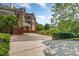 Brick house with a winding driveway surrounded by mature shade trees and green bushes at 218 W Barbee Chapel Rd, Chapel Hill, NC 27517