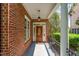 Inviting brick home entrance with a beautiful wooden door and elegant hanging lantern at 218 W Barbee Chapel Rd, Chapel Hill, NC 27517