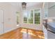 Sunlit kitchen nook with hardwood floors, views of the yard, and convenient access to the side door at 218 W Barbee Chapel Rd, Chapel Hill, NC 27517