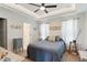 Cozy bedroom with tray ceiling, ceiling fan, carpet and ensuite bathroom at 221 Moon Cir, Dunn, NC 28334