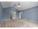 Bright bedroom with blue walls, vaulted ceiling, chandelier, and access to a closet and bathroom at 2216 Hoskins Rd, Burlington, NC 27215