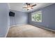 Bedroom features blue walls, a ceiling fan, and a window overlooking the yard at 2216 Hoskins Rd, Burlington, NC 27215