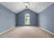 Spacious bedroom with blue walls, vaulted ceiling, chandelier and a window letting in natural light at 2216 Hoskins Rd, Burlington, NC 27215