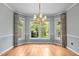 Bright dining room with large windows, a classic chandelier, and beautiful hardwood flooring at 2216 Hoskins Rd, Burlington, NC 27215