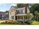 Charming two-story home featuring a covered porch, chimney, and landscaped garden at 2216 Hoskins Rd, Burlington, NC 27215