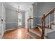Foyer with hardwood floors, staircase, chandelier, and natural light streaming through the window at 2216 Hoskins Rd, Burlington, NC 27215