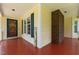 Covered front porch featuring yellow siding, red flooring, a brick support column, and 'Welcome' decor at 2216 Hoskins Rd, Burlington, NC 27215