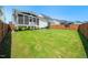 Lush green backyard with a screened porch and wooden fence, perfect for outdoor entertaining and relaxation at 245 Tumbling River Dr, Wendell, NC 27591