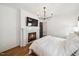 Bedroom features hardwood floors, a fireplace with a TV, a modern light fixture, and neutral decor at 245 Tumbling River Dr, Wendell, NC 27591
