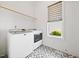 Functional laundry room with modern machines, patterned tile floor, and natural light at 245 Tumbling River Dr, Wendell, NC 27591
