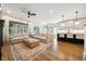 Open concept living room with sectional sofa, wood flooring, and an eat-in kitchen featuring barstool seating at 245 Tumbling River Dr, Wendell, NC 27591