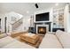 A traditional-style living room has a fireplace, built-in shelves, light-colored furniture, and wooden floors and stairs at 245 Tumbling River Dr, Wendell, NC 27591