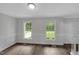 Dining room with wainscotting, wood floors, white trim, and windows with natural light at 248 Robin Loop, Dunn, NC 28334