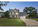 Charming two-story home with an attached garage, inviting front porch, and manicured lawn at dusk at 248 Robin Loop, Dunn, NC 28334