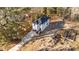 Aerial view of a white two-story home featuring a dark roof, front deck, and driveway in a wooded lot at 2513 Rochelle St, Durham, NC 27703