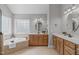 Bright bathroom with a soaking tub, double vanity with marble countertops, and natural light at 297 Curragh Cv, Fuquay Varina, NC 27526