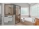 Bright bathroom featuring a separate shower, garden tub, and natural light from the window at 297 Curragh Cv, Fuquay Varina, NC 27526