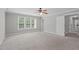 Spacious bedroom with neutral carpet, ceiling fan, and abundant natural light from large windows at 297 Curragh Cv, Fuquay Varina, NC 27526