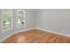 Cozy bedroom with hardwood floors and natural light streaming through two windows, creating a warm and inviting space at 297 Curragh Cv, Fuquay Varina, NC 27526