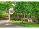 Charming home featuring a manicured lawn, mature trees, and a welcoming front porch with white railings and steps at 297 Curragh Cv, Fuquay Varina, NC 27526