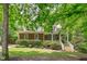 Charming home featuring a manicured lawn, mature trees, and a welcoming front porch with white railings and steps at 297 Curragh Cv, Fuquay Varina, NC 27526