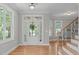 Bright foyer features hardwood floors, a staircase with iron railings, and abundant natural light from large windows at 297 Curragh Cv, Fuquay Varina, NC 27526