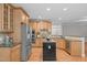 Well-lit kitchen with stainless steel appliances, custom cabinets, and an island at 297 Curragh Cv, Fuquay Varina, NC 27526