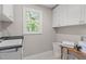 Laundry room with white cabinets, a utility sink, and a bright window at 297 Curragh Cv, Fuquay Varina, NC 27526