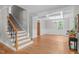 Elegant living room showcasing hardwood floors, a coffered ceiling, and large windows providing ample natural light at 297 Curragh Cv, Fuquay Varina, NC 27526