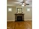 Bright living room boasts a cozy stone fireplace, ceiling fan, and hardwood floors at 297 Curragh Cv, Fuquay Varina, NC 27526