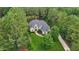 Aerial view of a brick house and a beautiful lawn surrounded by lush, mature trees at 3004 Krogen Ct, Creedmoor, NC 27522