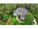 Aerial shot of a brick house with a well-manicured lawn surrounded by lush trees and landscaping at 3004 Krogen Ct, Creedmoor, NC 27522