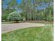 Manicured backyard with paver patio, stone fireplace and mature trees at 3004 Krogen Ct, Creedmoor, NC 27522