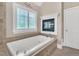 Bathroom featuring a soaking tub with tile surround and a window with transom at 3004 Krogen Ct, Creedmoor, NC 27522