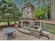 Custom outdoor stone fireplace and water feature with manicured landscaping at 3004 Krogen Ct, Creedmoor, NC 27522