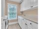 Bright laundry room featuring white cabinets, ample counter space, a large window, and modern appliances at 3004 Krogen Ct, Creedmoor, NC 27522