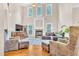 The living room features high ceilings, a fireplace, a TV, hardwood floors, and large windows at 3004 Krogen Ct, Creedmoor, NC 27522