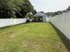 Expansive backyard with lush green lawn, enclosed by a white fence and featuring a covered patio at 306 W Canary St, Dunn, NC 28334