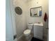 Half bath featuring new fixtures, neutral colors, with gray and white wallpaper at 306 W Canary St, Dunn, NC 28334