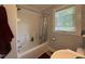 Clean bathroom features a bathtub and shower, accented by a window and neutral tones at 306 W Canary St, Dunn, NC 28334